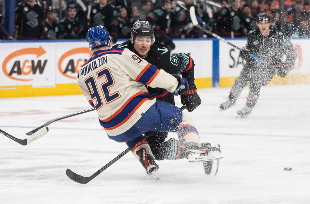 Seattle Kraken's Brandon Montour (62) checks Edmonton Oilers' Vasily Podkolzin (92) during second-period NHL hockey game action in Edmonton, Alberta, Thursday, Dec. 4, 2025. (Jason Franson/The Canadian Press via AP)