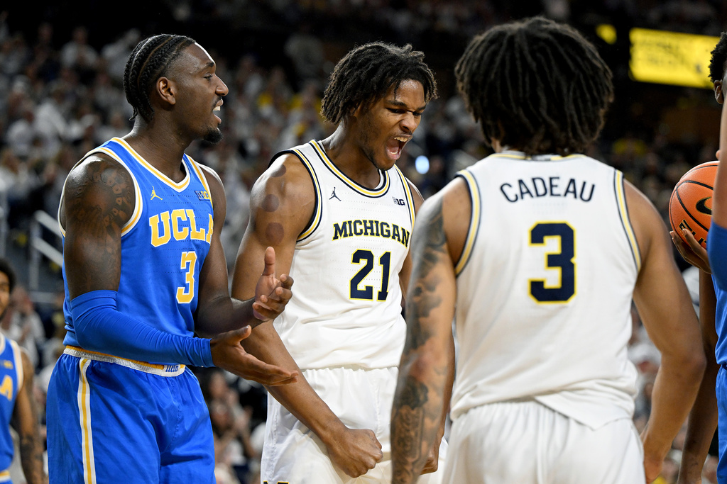 Michigan forward Morez Johnson Jr. (21) reacts after scoring a basket and drawing a foul from UCLA forward Eric Dailey Jr., left, in the first half of an NCAA college basketball game in Ann Arbor, Mich., Saturday, Feb. 14, 2026. (AP Photo/Lon Horwedel)
