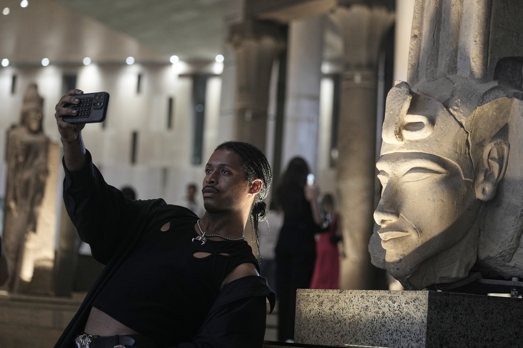 A tourist takes a selfie in front of Akhenaten statue during his visit to the Grand Egyptian Museum in Giza, Egypt, Friday, May 23, 2025. (AP Photo/Amr Nabil)