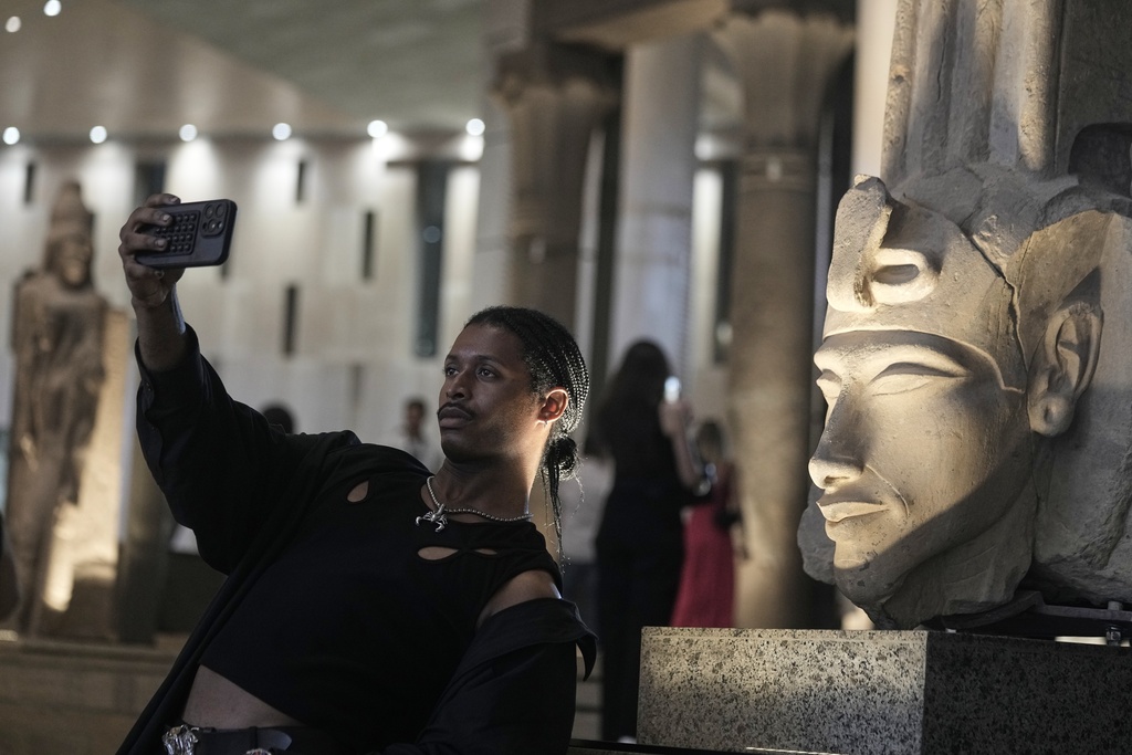A tourist takes a selfie in front of Akhenaten statue during his visit to the Grand Egyptian Museum in Giza, Egypt, Friday, May 23, 2025. (AP Photo/Amr Nabil)