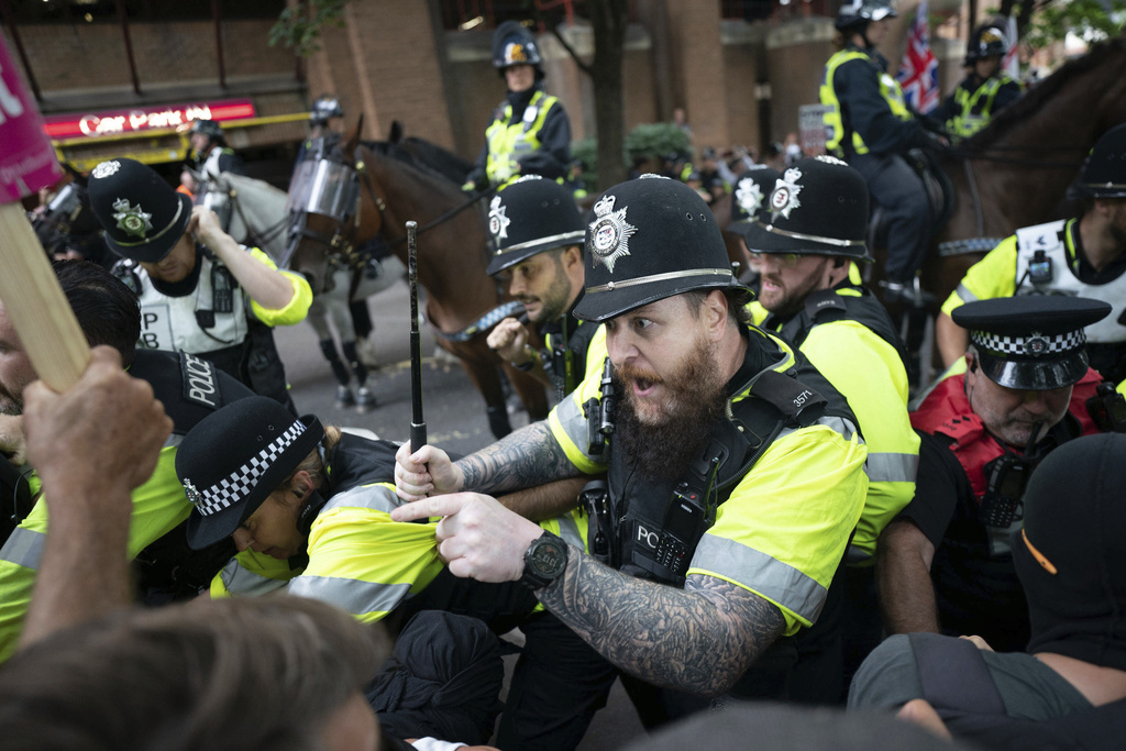 Mounted police officers scuffle with demonstrators during a protest by anti-migrant Abolish Asylum System and counter protesters at Castle Park in Bristol, England, Saturday, Aug. 23, 2025. (Ben Birchall/PA via AP)