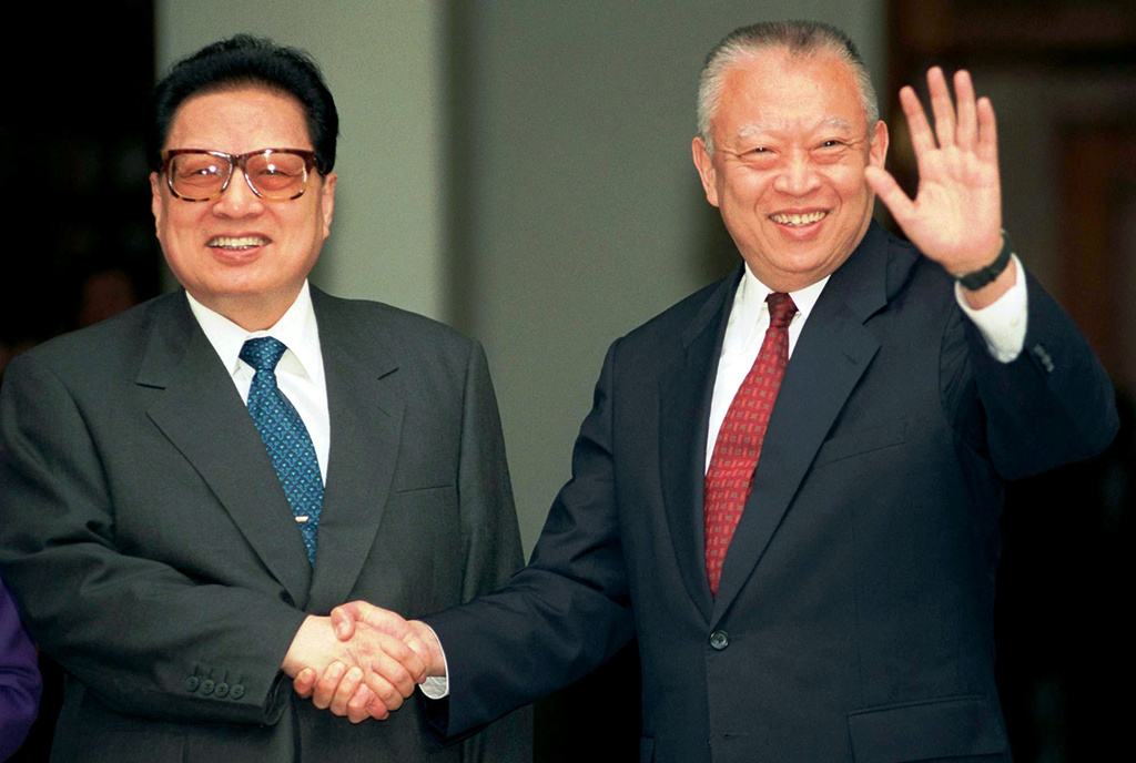 FILE - Hong Kong leader Tung Chee-hwa, right, waves to photographers while shaking hands with China's legislative leader Qiao Shi outside Government House in Hong Kong, Feb. 11, 1998. (AP Photo/Anat Givon, File)