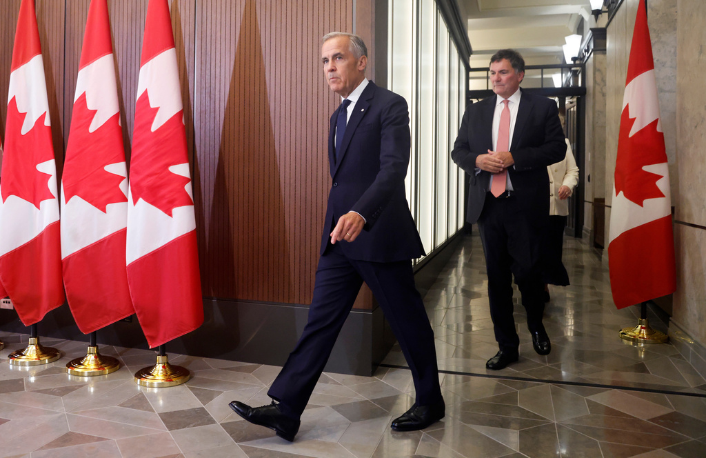 Prime Minister Mark Carney and Canada-U.S. Trade Minister Dominic LeBlanc arrive at a news conference about Canada's response to new U.S. tariffs on Parliament Hill in Ottawa on Saturday, Aug. 22, 2026. (Patrick Doyle/The Canadian Press via AP)