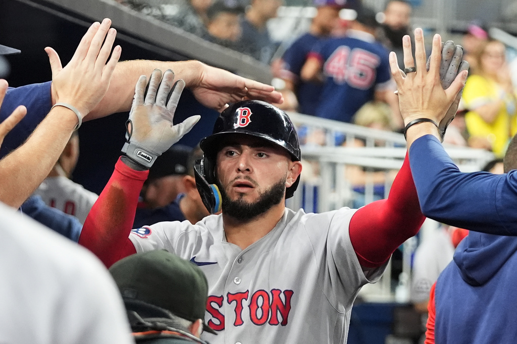 Boston Red Sox's Wilyer Abreu is congratulated in the dugout after scoring on a wild pitch thrown by Miami Marlins relief pitcher Josh Ekness during the eighth inning of a baseball game, Monday, Aug. 24, 2026, in Miami. (AP Photo/Lynne Sladky)
