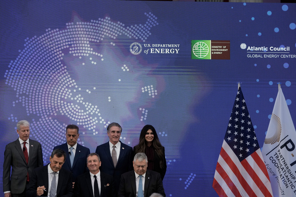 Chris Wright, Secretary of the U.S. Department of Energy, top left, Stavros Papastavrou, Greek Minister for Environment and Energy, top second left, Doug Burgum, U.S. Secretary of the Interior, top second right, and Kimberly Guilfoyle, U.S. Ambassador to Greece, top right, attend a signing ceremony from executives of Exxon Mobil, and Greek energy firms Helleniq Energy and Energean, during the Atlantic Council conference, in Athens, Greece, Thursday, Nov. 6, 2025. (AP Photo/Thanassis Stavrakis)