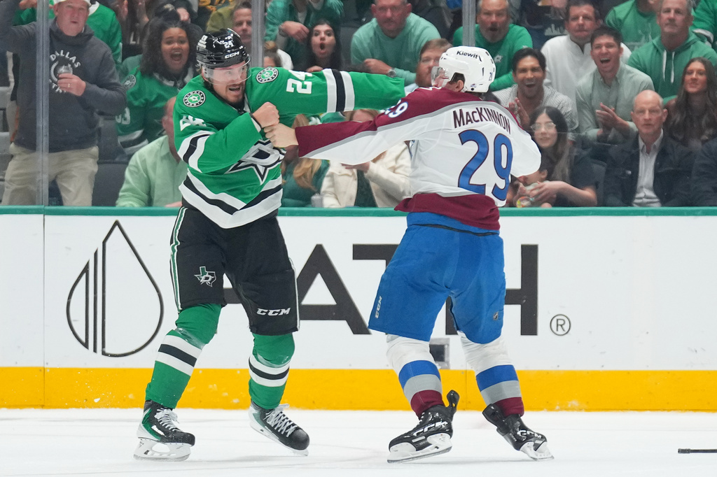 Dallas Stars center Roope Hintz (24) and Colorado Avalanche center Nathan MacKinnon (29) fight during the second period of an NHL hockey game Tuesday, Oct. 13, 2026, in Dallas. (AP Photo/Julio Cortez)