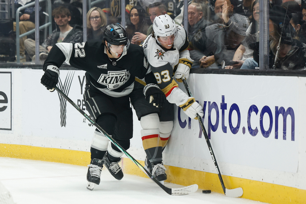 Los Angeles Kings left wing Kevin Fiala (22) and Vegas Golden Knights right wing Mitch Marner (93) fight for possession of the puck during the first period of an NHL hockey game Wednesday, Jan. 14, 2026, in Los Angeles. (AP Photo/Caroline Brehman)