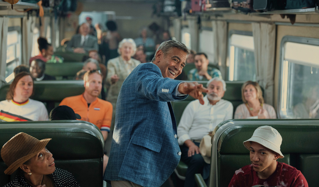 This image released by Netflix shows George Clooney, center, in a scene from "Jay Kelly." (Peter Mountain/Netflix via AP)