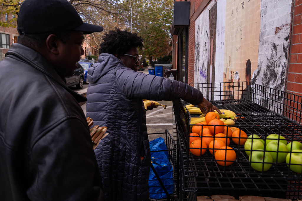 People take food from a One Love Community Fridge, Nov. 15, 2025, in Brooklyn, New York. (AP Photo/Adam Gray)