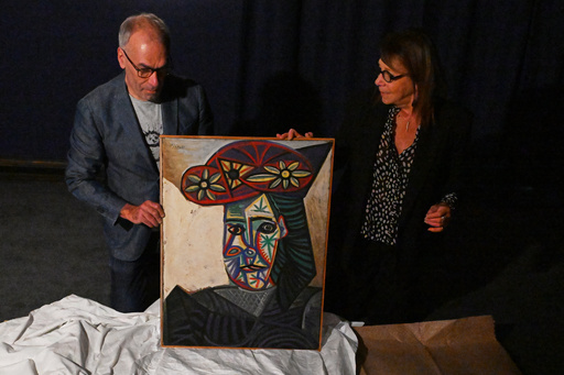 Art expert Agnes Sevestre-Barbe, right, and auction officer Christophe Lucien, display a rediscovered Picasso painting "Bust of a Woman in a Flowery Hat", Wednesday, Oct. 22, 2025 in Paris. The portrait painted in 1943 will be sold at auction Friday in Paris, was bought in 1944 and shows his partner Dora Maar. (AP Photo/Emma Da Silva) Art expert Agnes Sevestre-Barbe, right, and auction officer Christophe Lucien, display a rediscovered Picasso painting "Bust of a Woman in a Flowery Hat", Wednesday, Oct. 22, 2025 in Paris. The portrait painted in 1943 will be sold at auction Friday in Paris, was bought in 1944 and shows his partner Dora Maar. (AP Photo/Emma Da Silva)