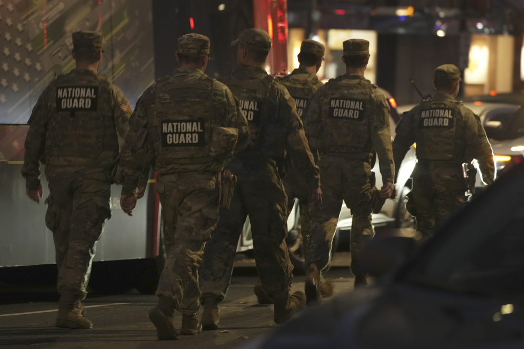Nation Guard move through the area following the shooting of two National Guard soldiers near the White House Wednesday, Nov. 26, 2025, in Washington. (AP Photo/Mark Schiefelbein)