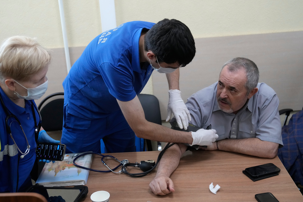 Emergency medical personnel provide care to Russian politician Boris Nadezhdin, right, accused of displaying "extremist symbols," during a break at a courtroom in the town of Dolgoprudny, outside Moscow, Russia, Friday, July 17, 2026. (AP Photo/Pavel Bednyakov)