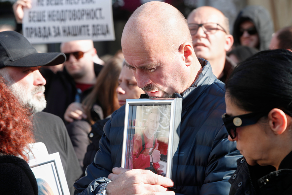 A man holds a picture of a Kocani nightclub fire victim, during a protest in Skopje, North Macedonia, on Saturday, Nov. 15, 2025, just a few days before the start of the trial for the fire. (AP Photo/Boris Grdanoski)