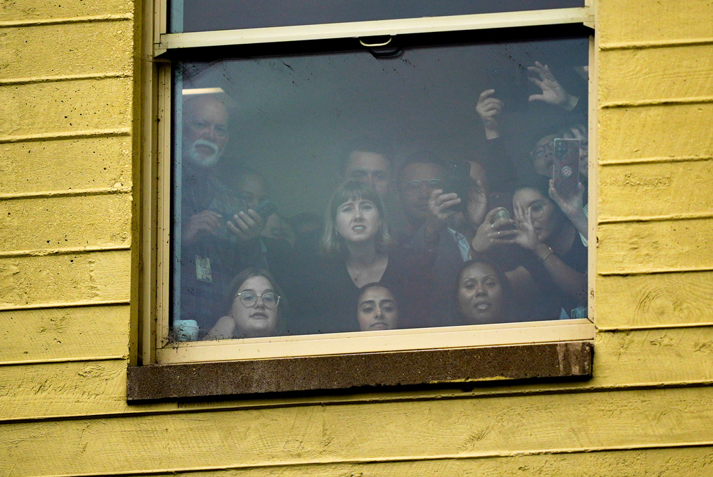 People watch from a window as President Donald Trump attends a ceremony in the Pentagon courtyard to commemorate the 24th anniversary of the 9/11 attacks, Thursday, Sept. 11, 2025, in Washington. (AP Photo/Julia Demaree Nikhinson)