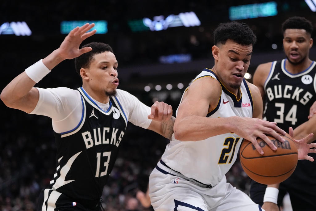 Denver Nuggets' Spencer Jones tries to get past Milwaukee Bucks' Ryan Rollins during the first half of an NBA basketball game Friday, Jan. 23, 2026, in Milwaukee. (AP Photo/Morry Gash)