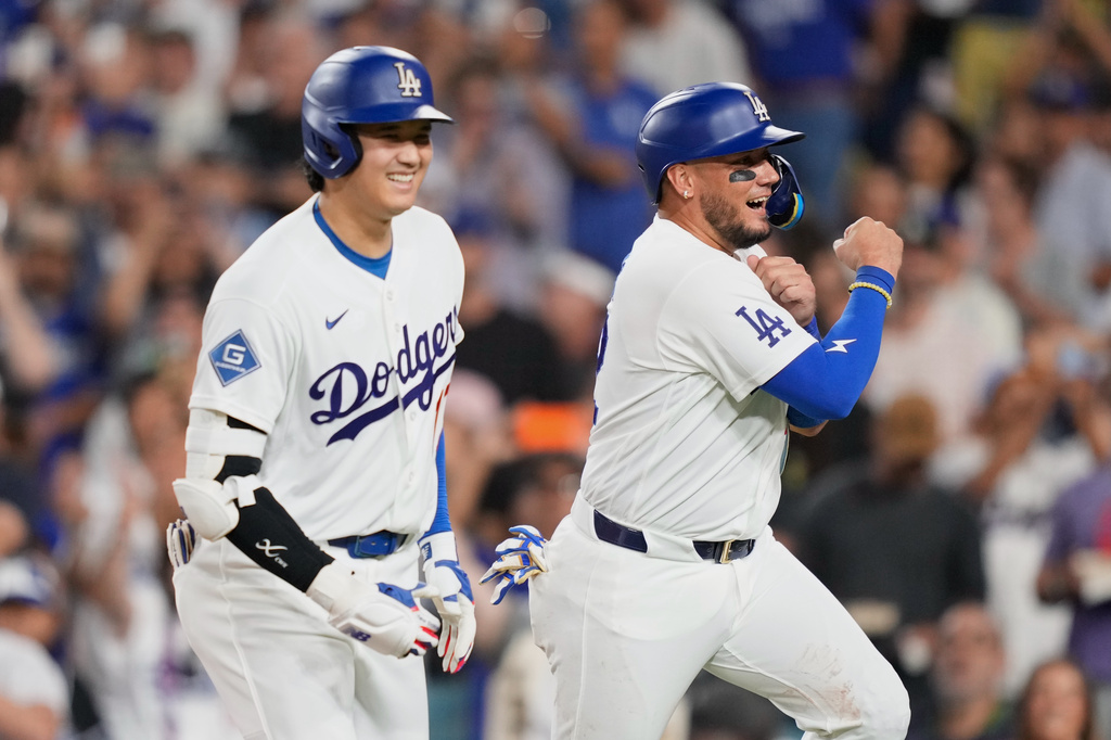 Los Angeles Dodgers' Shohei Ohtani, left, celebrates with Miguel Rojas after hitting a two-run home run during the third inning of a baseball game against the Kansas City Royals, Wednesday, Aug. 12, 2026, in Los Angeles. (AP Photo/Mark J. Terrill)