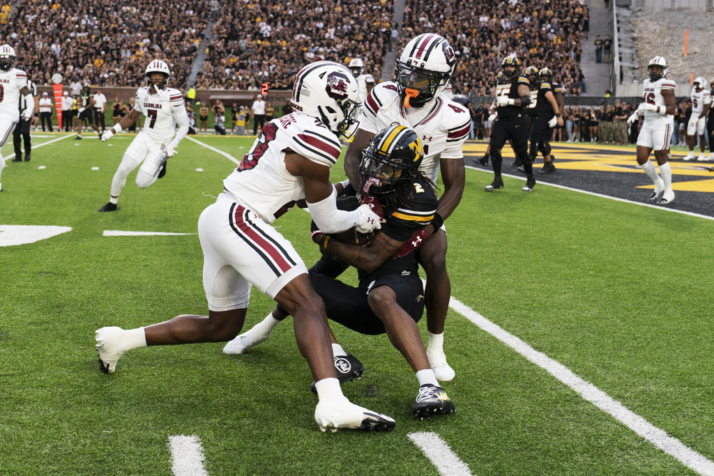 Missouri's Marquis Johnson (2) is tackled by South Carolina's Gerald Kilgore, left, and Vicari Swain, right, during the first half of an NCAA college football game Saturday, Sept. 20, 2025, in Columbia, Mo. (AP Photo/L.G. Patterson)