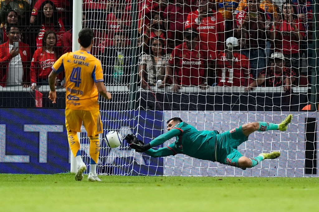 Toluca's goalkeeper Luis Garcia, right, blocks a shot by Tigres' Juan Purata during a penalty shootout on the CONCACAF Champions Cup final soccer match in Toluca, Mexico, Saturday, May 30, 2026. (AP Photo/Fernando Llano)