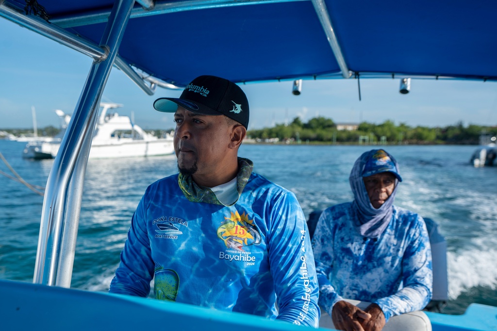 Alido Luis Báez, left, accompanied by his father Alido Luis Brito leave the port for a day of artisanal fishing in Bayahibe, Dominican Republic on Oct. 20, 2025. (AP Photo/Francesco Spotorno)