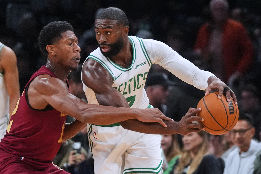 Cleveland Cavaliers forward De'Andre Hunter, left, pressures Boston Celtics guard/forward Jaylen Brown (7) during the first half of an NBA basketball game, Wednesday, Oct. 29, 2025, in Boston. (AP Photo/Charles Krupa)