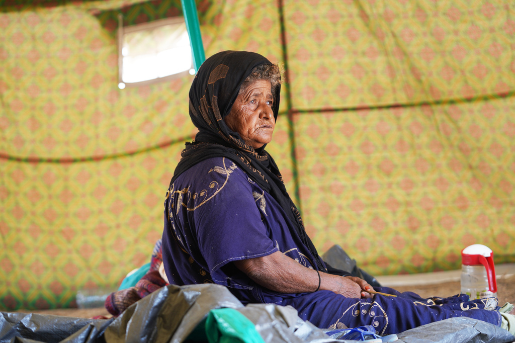 Salma Mohammed, 60, a displaced Yemeni woman, sits inside her tent at the Al-Firdaws camp in Ras Imran, just outside Aden, Yemen, Monday, Sept. 14, 2026. (AP Photo/Abdulnasser Alseddik)