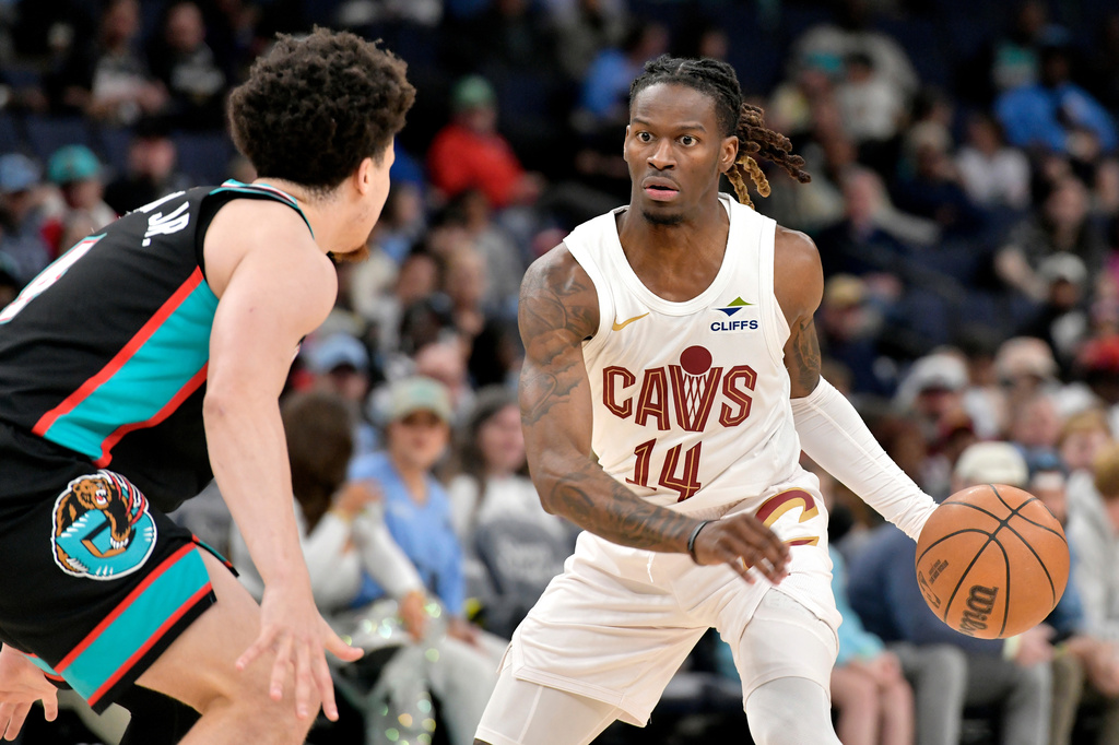 Cleveland Cavaliers guard Keon Ellis (14) handles the ball against Memphis Grizzlies forward Tyler Burton Jr., left. in the first half of an NBA basketball game Monday, April 6, 2026, in Memphis, Tenn. (AP Photo/Brandon Dill)