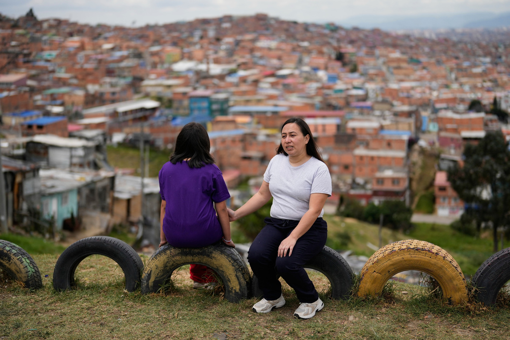 Andrea Armero, right, and her daughter, who were deported from the United States, sit in a park in Colombia, on Wednesday, Feb. 18, 2026. (AP Photo/Fernando Vergara)