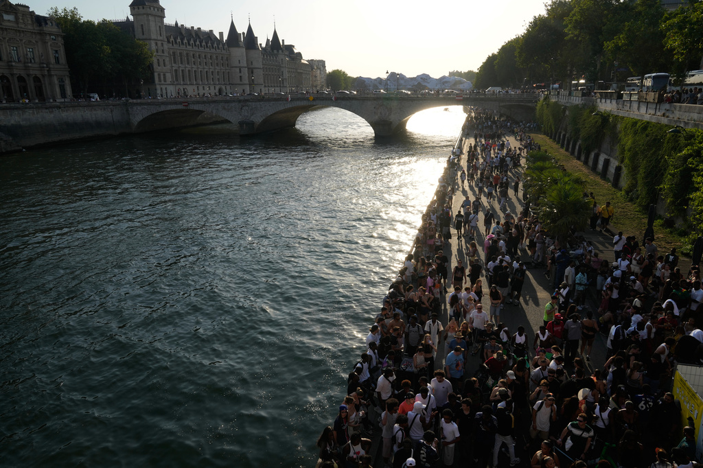 People walk along the Seine river during music day in Paris, Sunday, June 21, 2026. (AP Photo/Michel Euler)