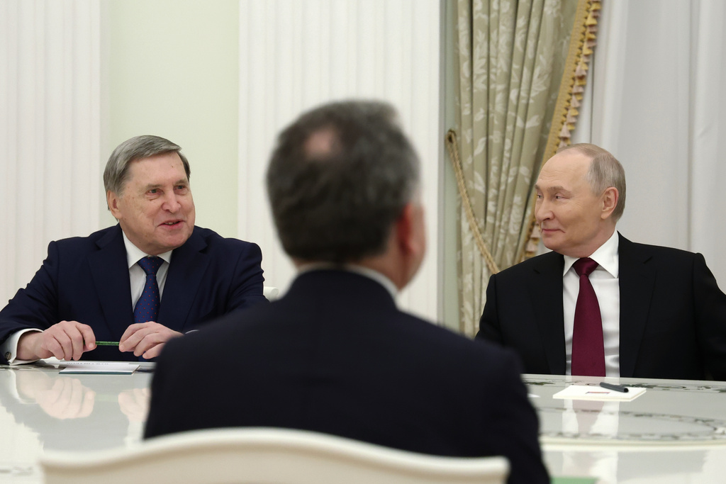Russian President Vladimir Putin, right, and Russian Presidential foreign policy adviser Yuri Ushakov, left, attend talks with U.S. special envoy Steve Witkoff, back to a camera, at the Senate Palace of the Kremlin in Moscow, Russia, Tuesday, Dec. 2, 2025. (Alexander Kazakov, Sputnik, Kremlin Pool Photo via AP)