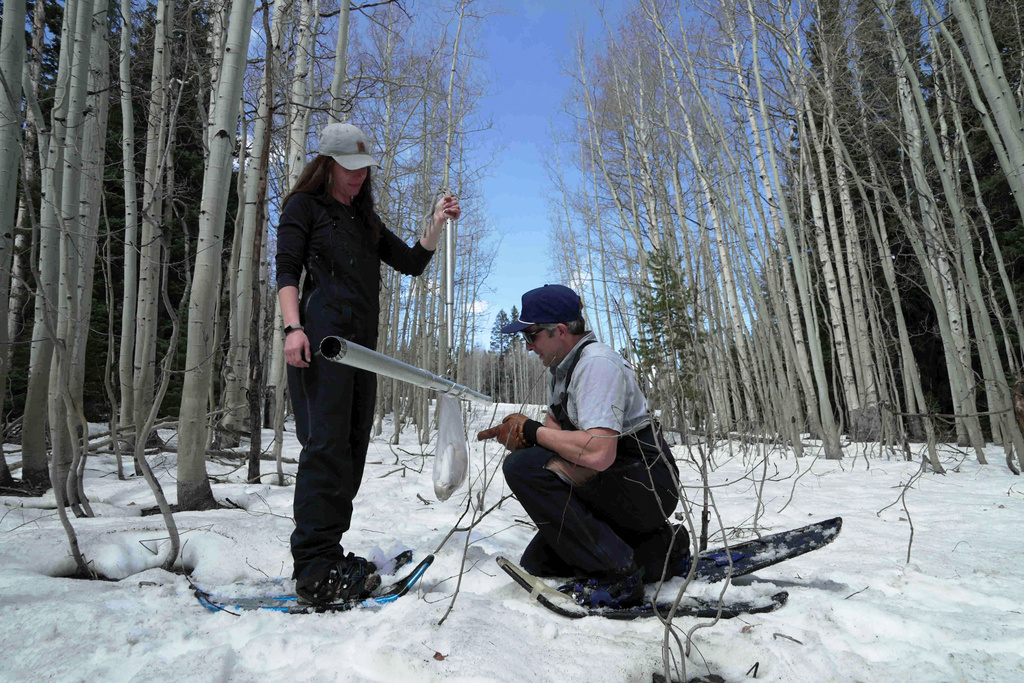 Snow surveyors, hydrologist, Maureen Gutsch, left, and Clinton Whitten weigh a snow sample, Monday, March 30, 2026, in Kremmling, Colo. (AP Photo/Brittany Peterson)