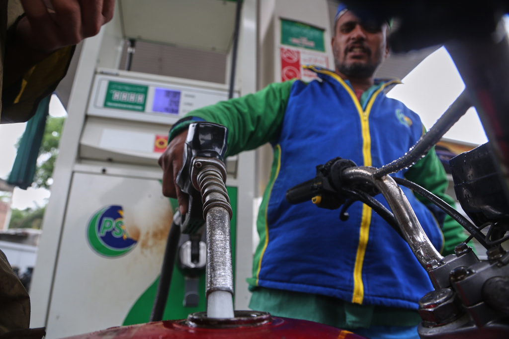 A worker fills fuel into a motorbike after the government increased fuel prices amid surging global oil prices due to the Iran war, in Peshawar, Pakistan, Friday, April 3, 2026. (AP Photo/Muhammad Sajjad)