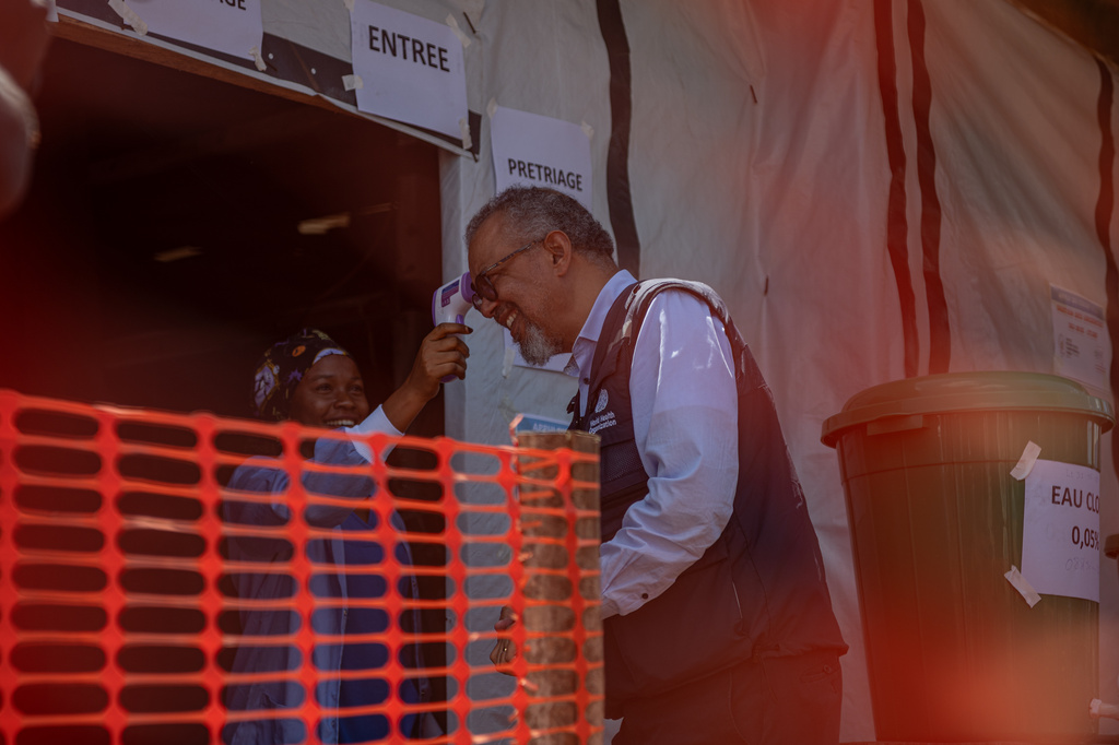 A health worker takes the temperature of the Director General of the World Health Organisation (WHO), Tedros Adhanom Ghebreyesus, who arrived to meet health workers who recovered from Ebola in Bunia, Congo, Sunday, May 31, 2026. (AP Photo/Moses Sawasawa)