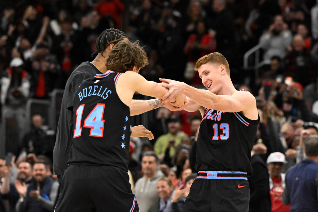 Chicago Bulls guard Kevin Huerter (13) celebrates with forward Matas Buzelis and forward Dalen Terry, back, after he scores the game winning three-point basket over the Boston Celtics during the second half of an NBA basketball game Saturday, Jan. 24, 2026, in Chicago. (AP Photo/Matt Marton)