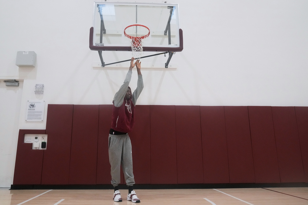 Santa Clara basketball player Thierry Darlan grabs a basketall net while being interviewed on the Santa Clara University campus in Santa Clara, Calif., Thursday, Nov. 13, 2025. (AP Photo/Jeff Chiu)