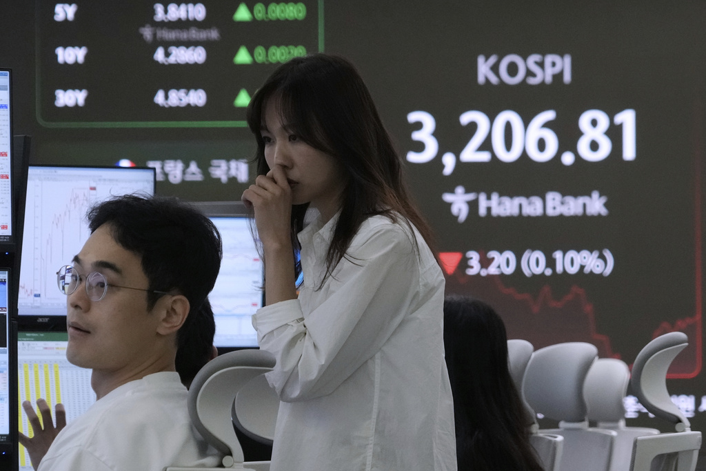 Currency traders watch monitors near a screen showing the Korea Composite Stock Price Index (KOSPI) at the foreign exchange dealing room of the Hana Bank headquarters in Seoul, South Korea, Monday, Aug. 11, 2025. (AP Photo/Ahn Young-joon)
