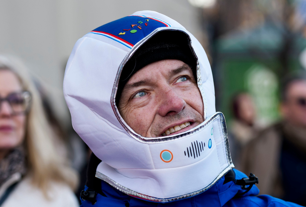 Ottawa city councillor Tim Tierney wears a costume astronaut helmet as he joins others watching the launch of Artemis II on a livestream displayed on the Kipnes Lantern of the National Arts Centre in Ottawa, Ontario, Wednesday, April 1, 2026. (Justin Tang/The Canadian Press via AP)