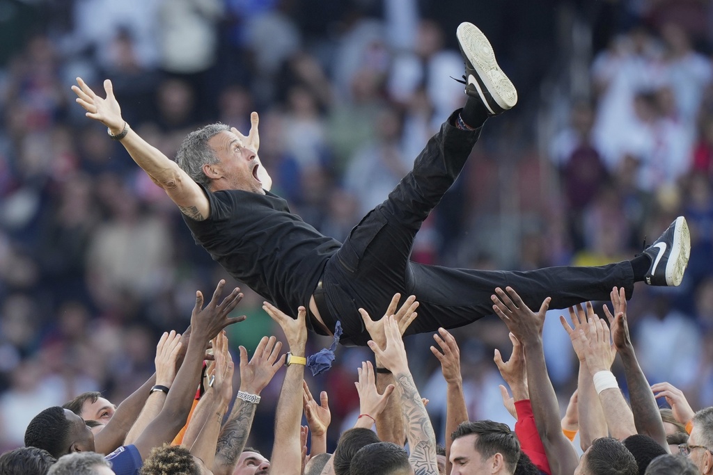 FILE- Paris Saint-Germain players throw PSG's head coach Luis Enrique in the air after they won the French League One soccer match between Paris Saint-Germain and Angers at Parc des Princes stadium in Paris, April 5, 2025. (AP Photo/Michel Euler, file)