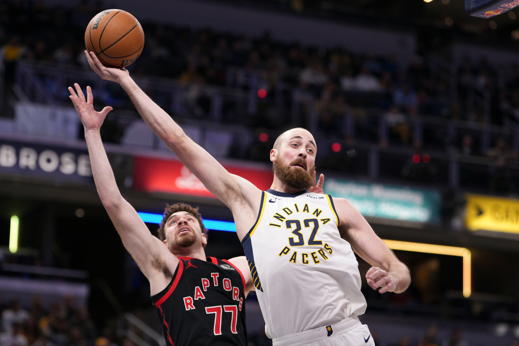 Indiana Pacers center Jay Huff (32) saves a ball from going out of bounds in front of Toronto Raptors forward Jamison Battle (77) during the first half of an NBA basketball game in Indianapolis, Wednesday, Jan. 14, 2026. (AP Photo/AJ Mast)