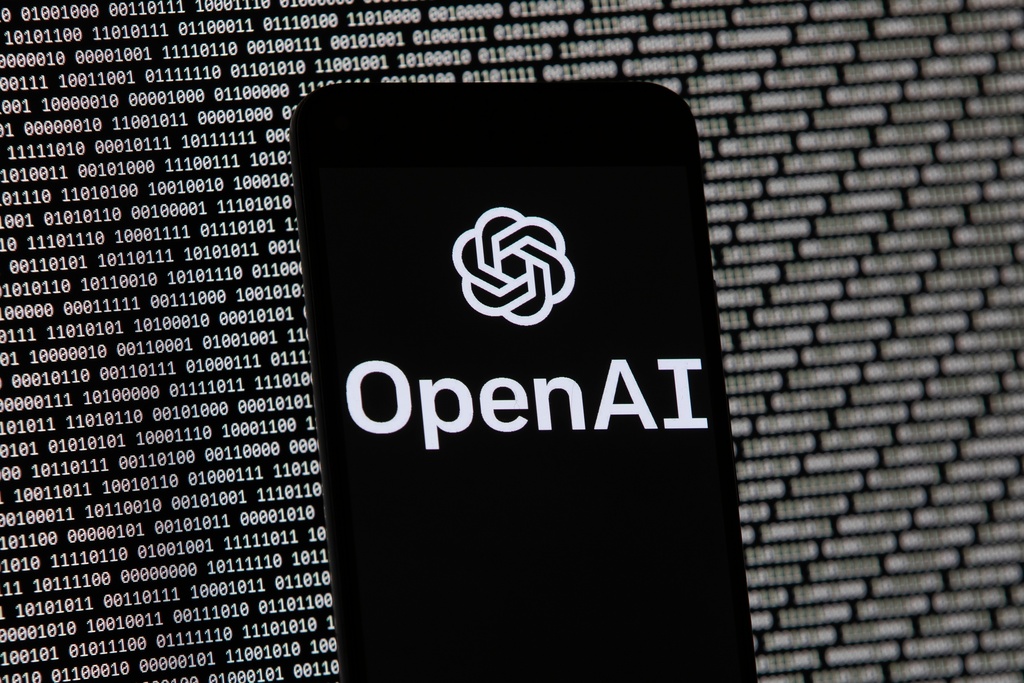 ARCHIVO - El logotipo de OpenAI aparece en un teléfono móvil frente a una pantalla de computadora con datos binarios aleatorios, el 9 de marzo de 2023, en Boston. (AP Foto/Michael Dwyer/Archivo)