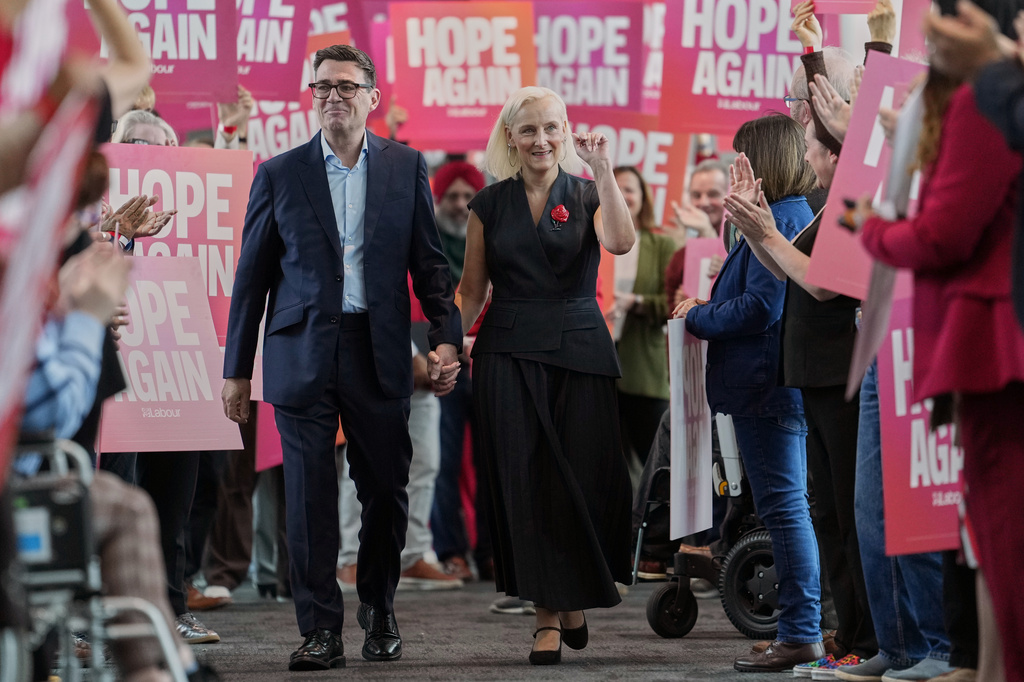 Britain's Prime Minister Andy Burnham and his wife Marie-France van Heel are greeted by supporters ahead of the Leaders Speech at the Labour Party Conference in Liverpool, England, Tuesday, Sept. 29, 2026. (AP Photo/Jon Super)