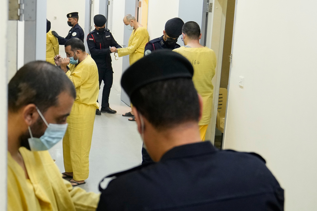 Iraqi security forces lead suspected Islamic State militants for questioning, after they were transferred from Syria to Iraq, at Al-Karkh Central Prison in Baghdad, Iraq, Thursday, Feb. 12, 2026. (AP Photo/Hadi Mizban)