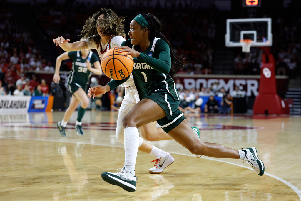 Michigan State guard Rashunda Jones (1) drives past Oklahoma guard Aaliyah Chavez (2) during the first half in the second round of the NCAA college basketball tournament, Sunday, March 22, 2026, Norman, Okla. (AP Photo/Alonzo Adams)