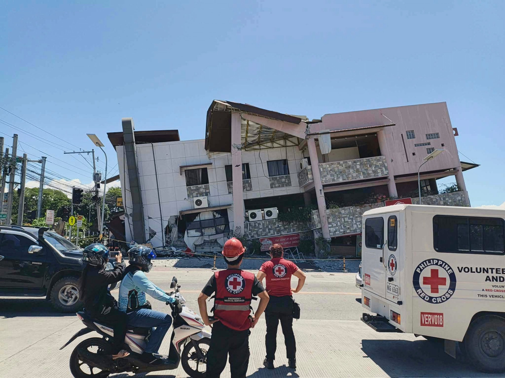 In this photo provided by the Philippine Red Cross, rescuers inspect the damage after an earthquake in General Santos, Philippines, Monday, June 8, 2026. (Philippine Red Cross via AP)