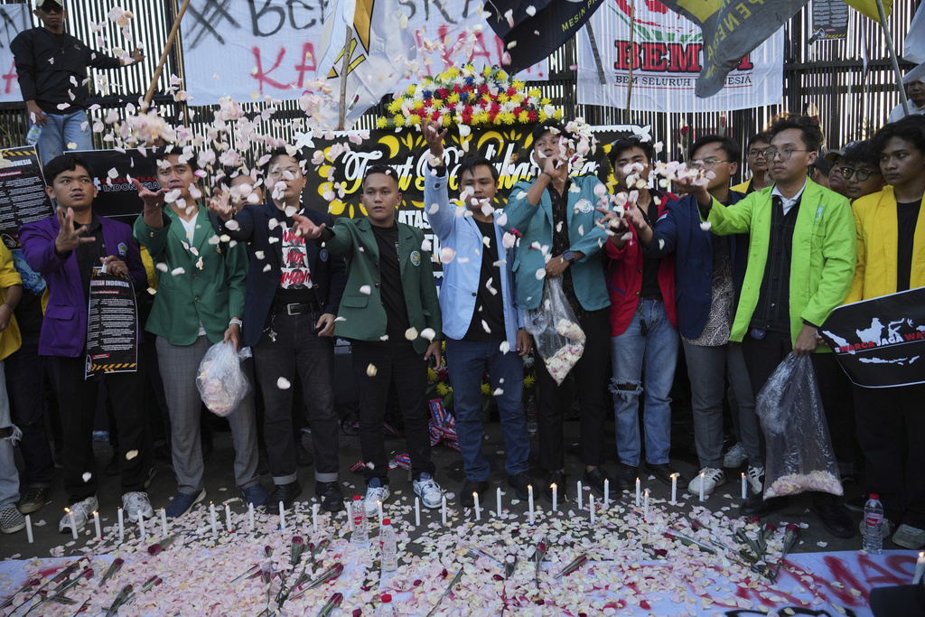 Student protesters throw flowers during a rally against corruption, politicization of law, and lavish allowances given to parliament members, outside the parliament building in Jakarta, Indonesia Thursday, Sept. 4, 2025. (AP Photo/Tatan Syuflana)
