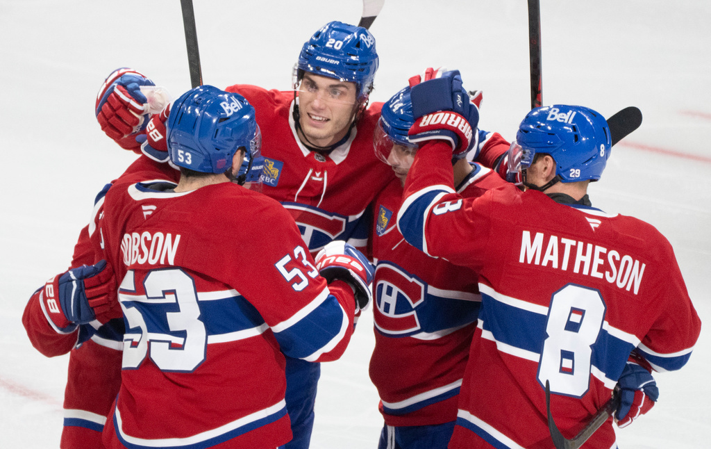 Montreal Canadiens' Juraj Slafkovský (20) celebrates his goal over the Buffalo Sabres with teammates from left to right Noah Dobson (53), Cole Caufield (13), Nick Suzuki (14) and Mike Matheson (8) during third period NHL hockey action in Montreal on Monday, Oct. 20, 2025. (Christinne Muschi/The Canadian Press via AP)