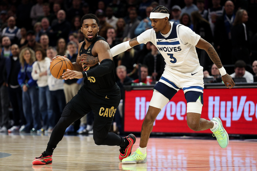 Cleveland Cavaliers guard Donovan Mitchell, left, works around Minnesota Timberwolves forward Jaden McDaniels (3) during the first half of an NBA basketball game, Thursday, Jan. 8, 2026, in Minneapolis. (AP Photo/Matt Krohn)