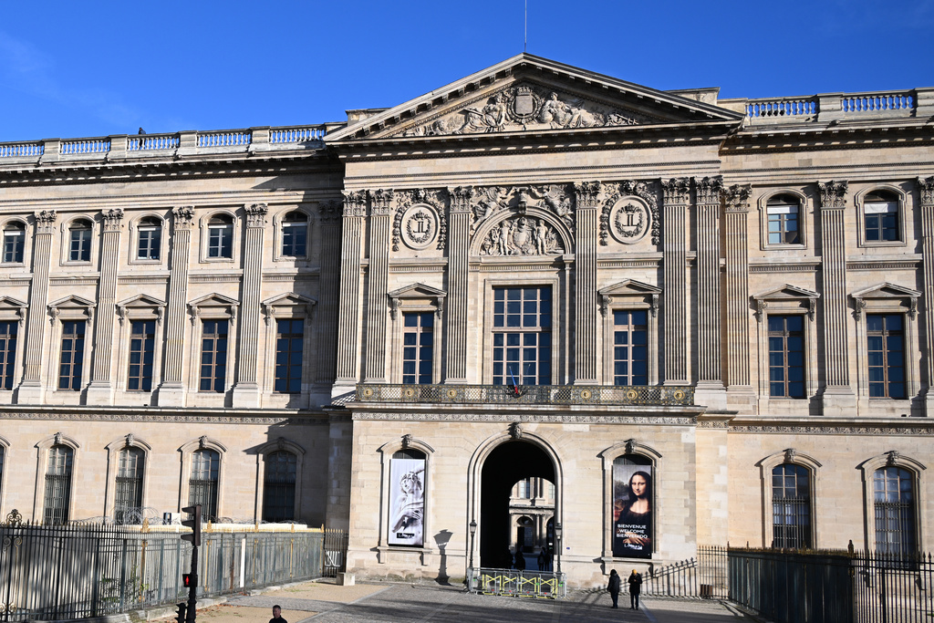 FILE- People walk by an entrance of the Louvre museum, Thursday, Oct. 30, 2025 in Paris. (AP Photo/Emma Da Silva, file)