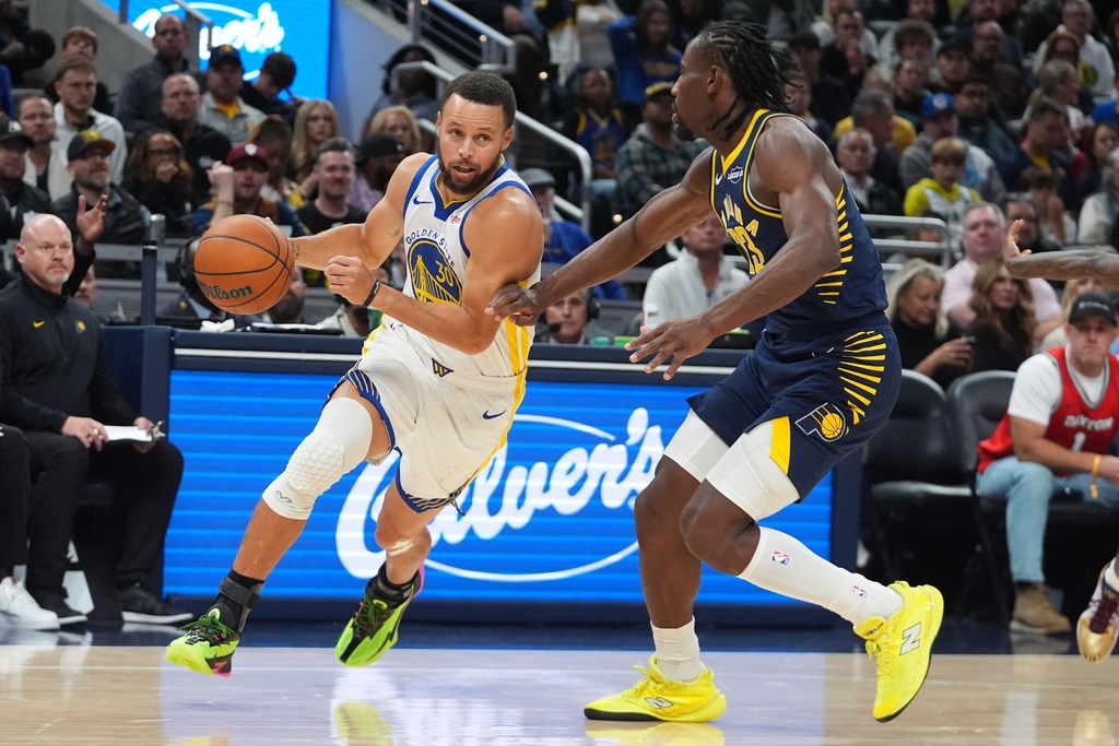 Golden State Warriors' Stephen Curry (30) goes to the basket against Indiana Pacers' Aaron Nesmith (23) during the first half of an NBA basketball game, Saturday, Nov. 1, 2025, in Indianapolis. (AP Photo/Darron Cummings)