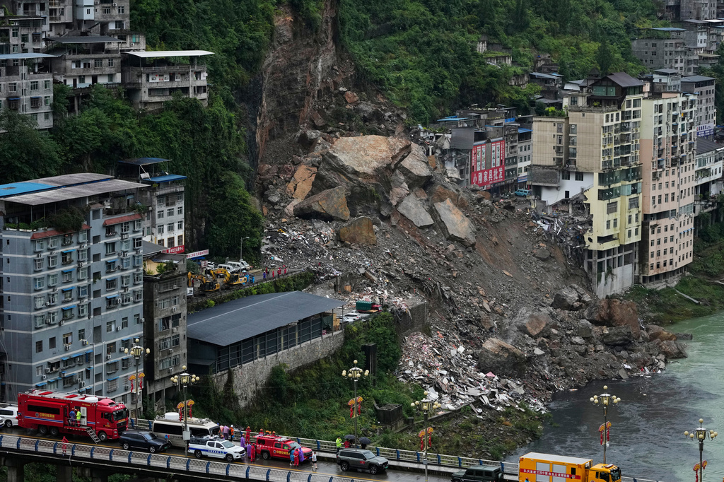Rescuers stand by along the bridge as they prepare to conduct a search and rescue operation at the scene of a landslide in Pengshui County in southwestern China's Chongqing on Saturday, July 18, 2026. (AP Photo/Andy Wong)