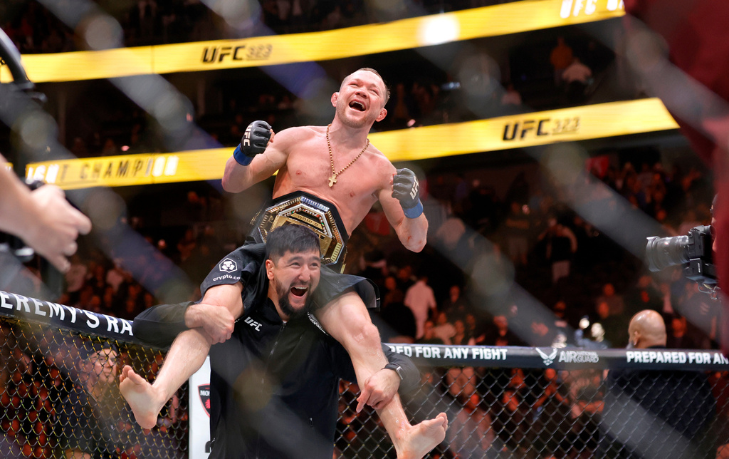 Petr Yan celebrates with a member of his team after defeating UFC bantamweight champion Merab Dvalishvili during UFC 323 Saturday, Dec. 6, 2025, in Las Vegas. (Steve Marcus/Las Vegas Sun via AP)